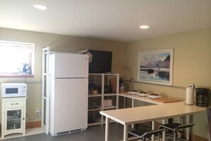 Eine kleine Küche mit Kühlschrank, Mikrowelle und Esstisch.