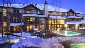 Een resort met meerdere gebouwen, buitenzwembaden en een besneeuwde omgeving.