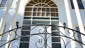 A building with a large arched window and a decorative iron gate.