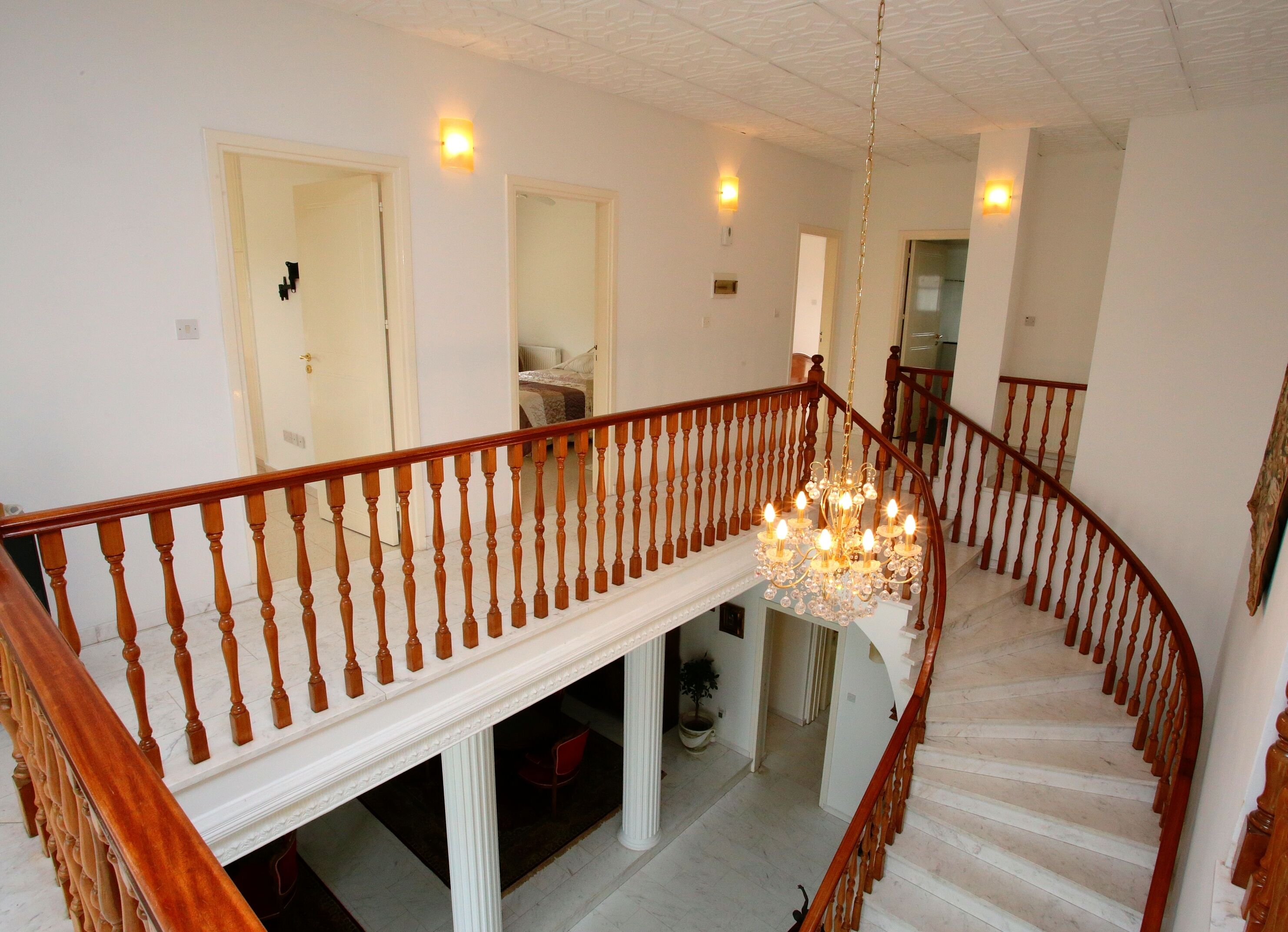 Un magnifique escalier avec une rampe en bois et un lustre.