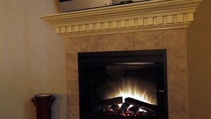 A fireplace with a TV mounted above it. - Legacy Suite on Main St in central downtown, jacuzzi tub, ask about Wine Tours!! (Fredericksburg)