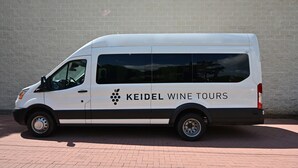 A white van with "KEIDEL WINE TOURS" branding parked against a brick wall. - Legacy Suite on Main St in central downtown, jacuzzi tub, ask about Wine Tours!! (Fredericksburg)