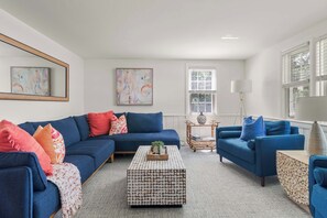 A modern living room with a sectional sofa, a coffee table, and a side table.