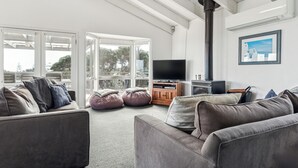 Un salon moderne avec un canapé gris, un téléviseur et une cheminée.