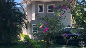 A two-story building with a tiled roof and a small garden area in front. - House rental in Toque Toque Grande - São Sebastião (North Coast of SP) (São Sebastião)