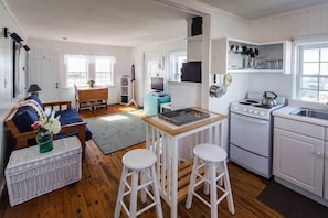 Enjoy cooking and dining in this well-equipped kitchen and living area, featuring a stove, sink, and dining table.