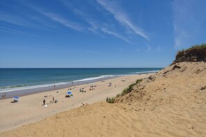 A sandy beach with people, umbrellas, and a clear blue sky. - Across from Mayo Beach walk to downtown! (Wellfleet)