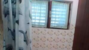 A bathroom with a bathtub, a sink, and a window with curtains.