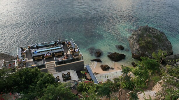 Une terrasse extérieure avec des sièges et une vue sur la mer.