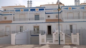 A white building with blue accents, a gated entrance, and a staircase leading to the entrance. - SEASIDE VILLA WITH PRIVATE SWIMMING POOL  (Manta Rota)