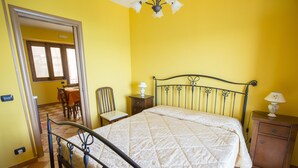 Une pièce comprenant un lit, une chaise, une table et une lampe.