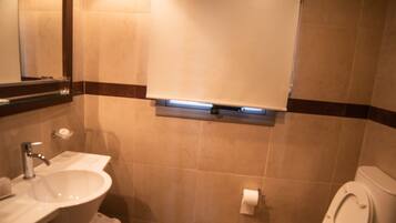 Un baño con lavabo, inodoro y espejo.