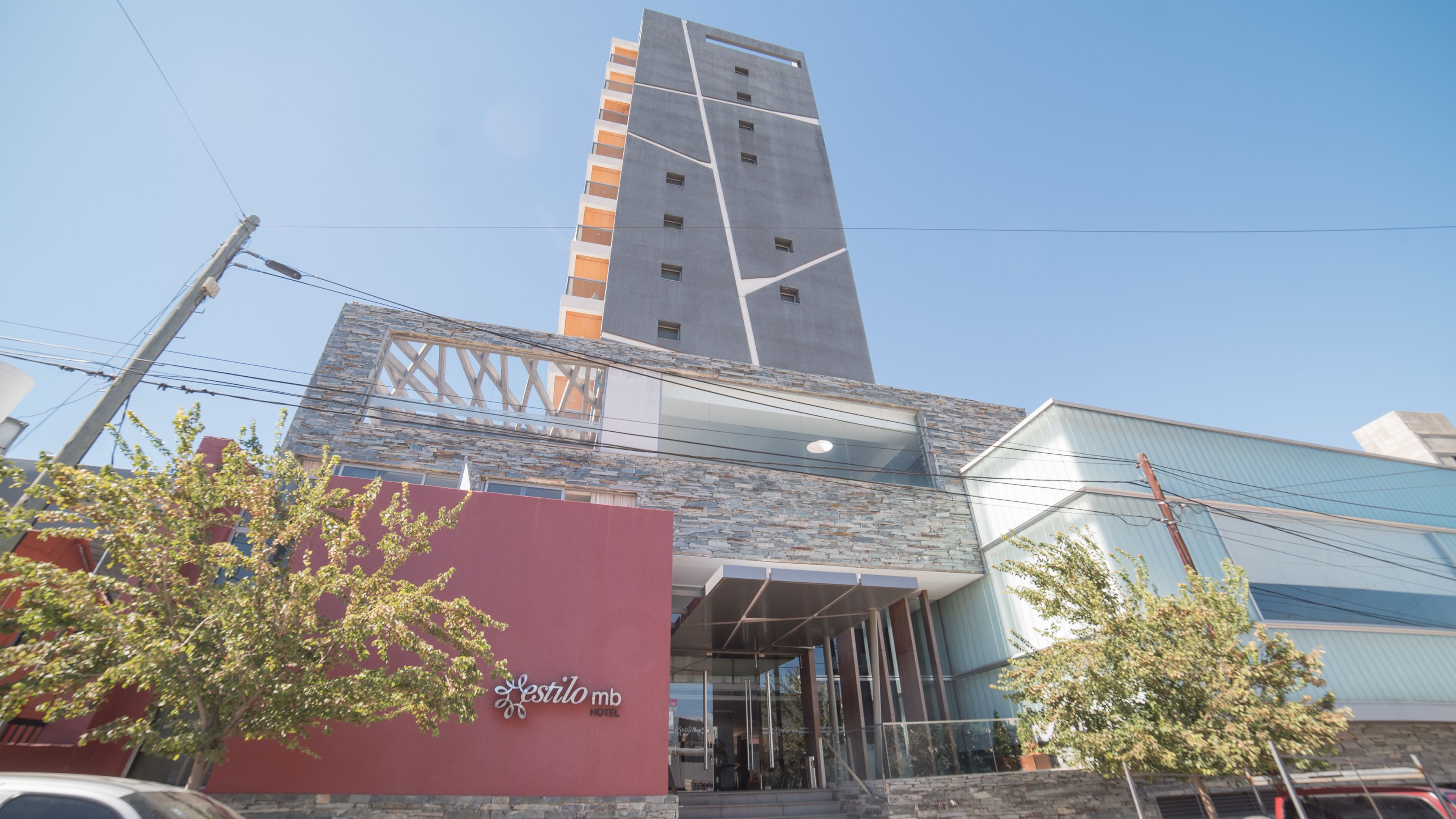 Un hotel de diseño moderno, con una estructura prominente tipo torre y fachada de piedra.