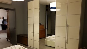 Een slaapkamer met een bed, een kledingkast, een dressoir en een spiegel.