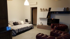 Een moderne woonkamer met een bank, een televisie en een kast.