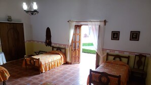 A room with two beds, a wooden wardrobe, a table, and a chair. - Ex-Hacienda San Buenaventura (Tlaxco)