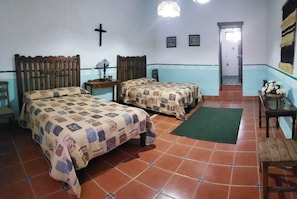 A room with two beds, a cross on the wall, and a green mat on the floor. - Ex-Hacienda San Buenaventura (Tlaxco)