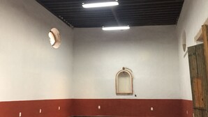 A spacious room with a high ceiling, exposed beams, and a red and white wall color scheme. - Ex-Hacienda San Buenaventura (Tlaxco)