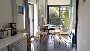 A modern kitchen with a dining area, a dishwasher, and a table set for two.