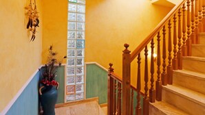 A staircase with wooden balusters and a handrail, leading to an upper floor.