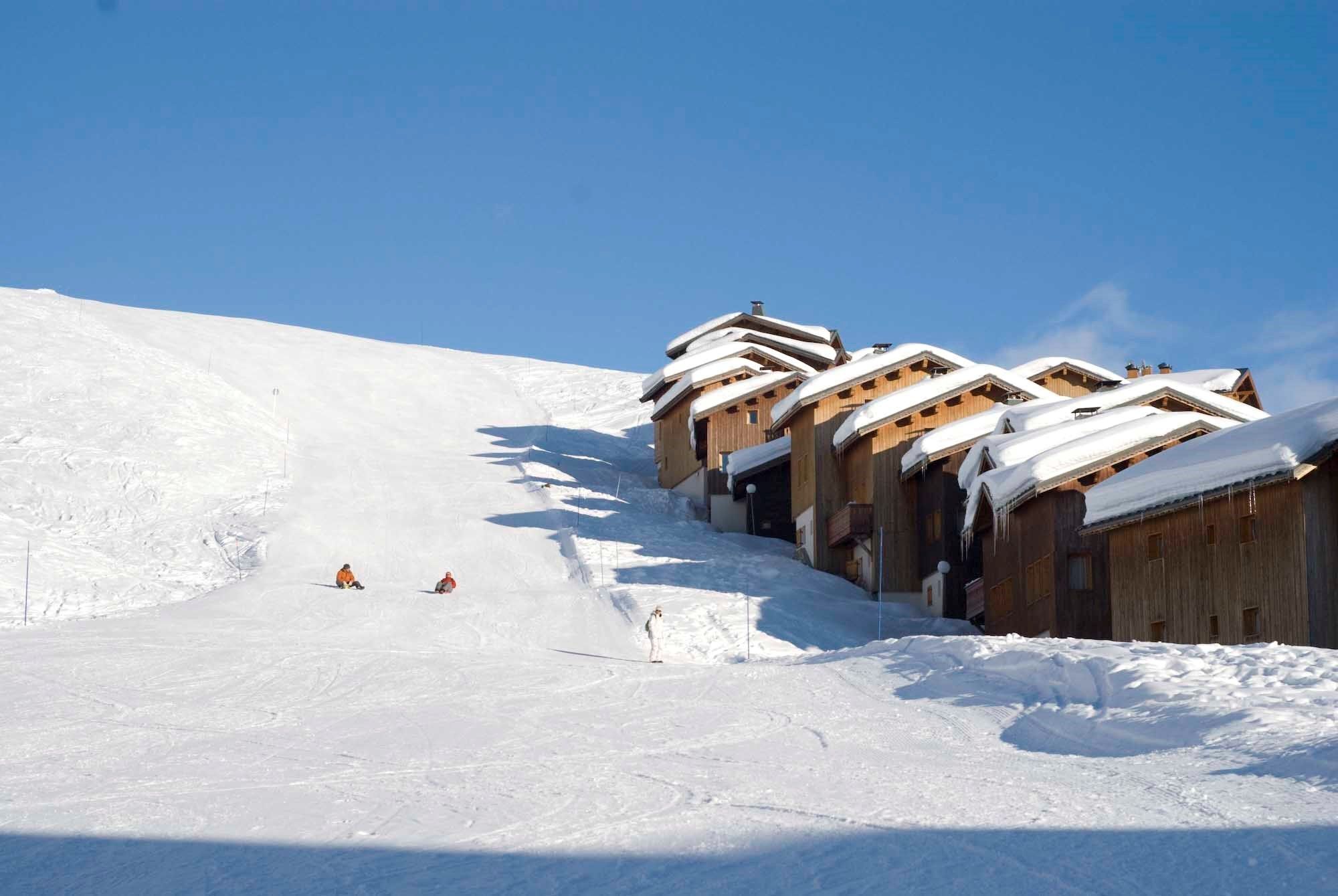 Ein mit Schnee bedeckter Ski-Hang mit Holzchalets.