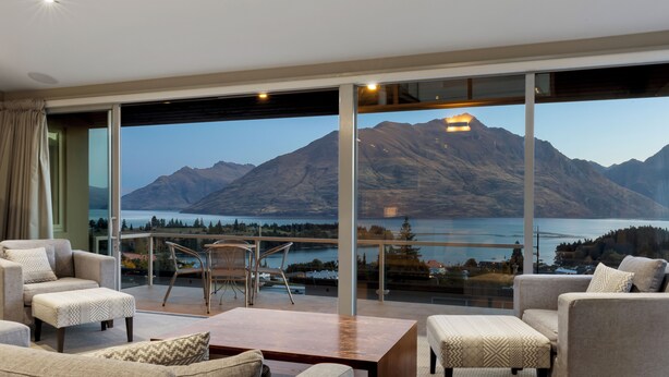 A modern living room with a large glass wall offering a mountain view. - Remarkable Location – Queenstown (Queenstown)