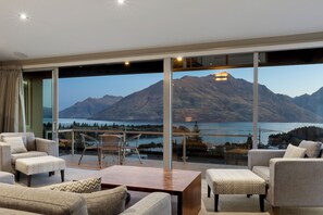 Een moderne woonkamer met een grote glazen wand met uitzicht op de bergen.