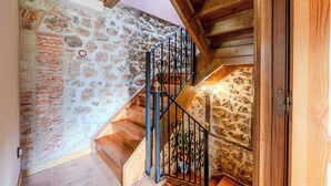 A wooden staircase with a stone wall on one side and a wooden ceiling on the other. - Casa Dolores for 6 people (Cabrales)