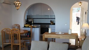 A compact living space with a dining area, kitchen, and a cozy seating area. - Quiet house and panoramic views  (Denia)