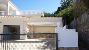 A white building with a gated entrance, a garage, and a balcony. - Quiet house and panoramic views  (Denia)