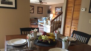 A dining table set with plates, cutlery, and a fruit centerpiece. - All inclusive, 2 bed 2 bath, pool, perfect location!  (Fort Myers)