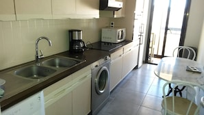 A compact kitchen with a sink, coffee maker, microwave, and washing machine. - APARTMENT IN SAINTE MAXIME (Sainte-Maxime)