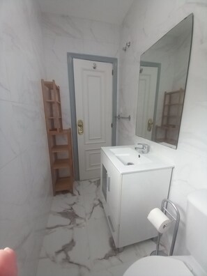Een bad/douchecombinatie, een haardroger, een bidet, handdoeken