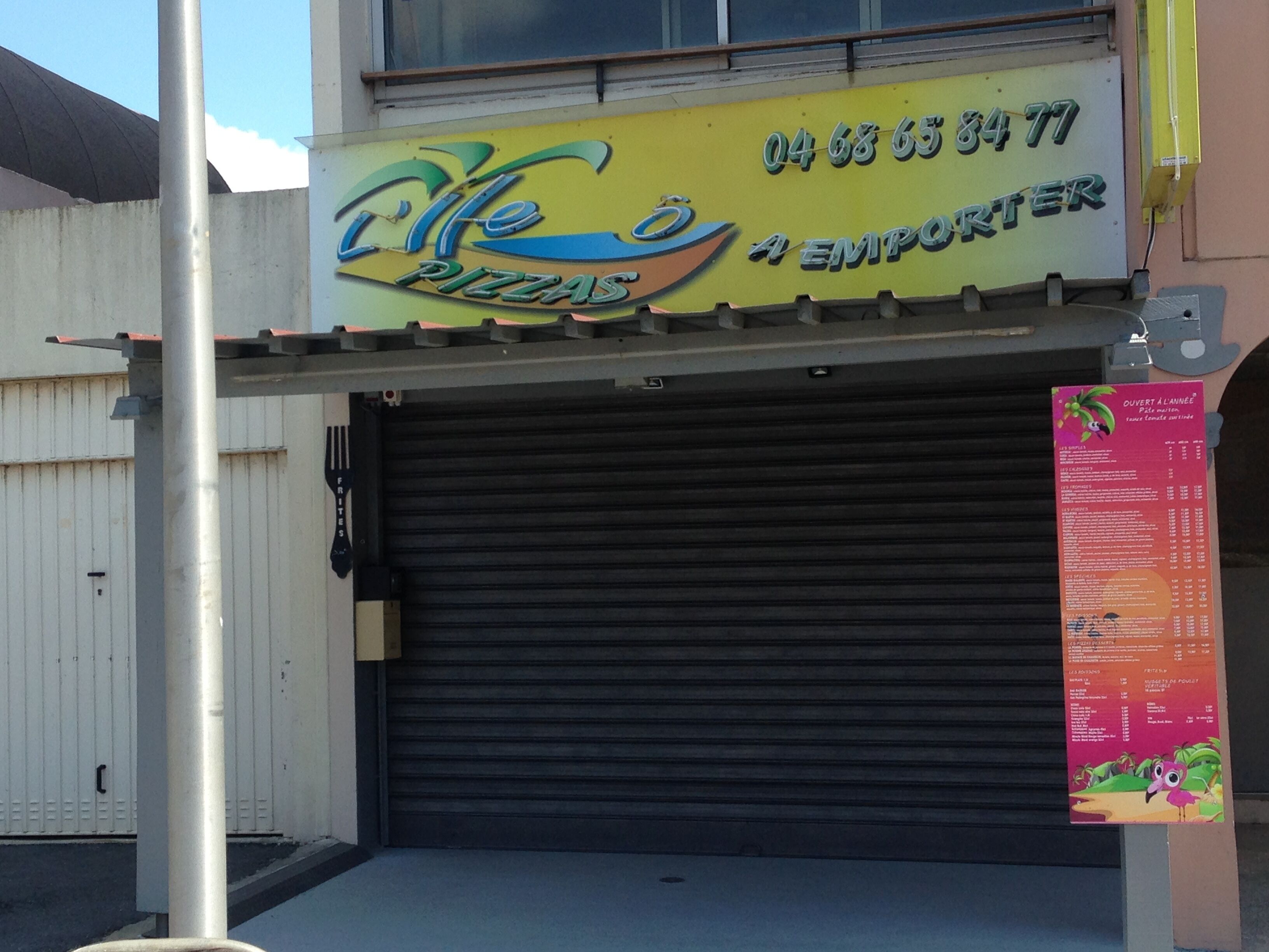 Een gesloten winkel met een geel bord waarop 'Life Pizzas' staat en een telefoonnummer.
