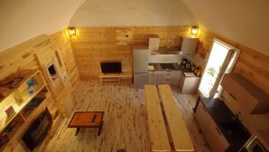 A compact, wooden interior with a kitchen, dining area, and a fireplace.