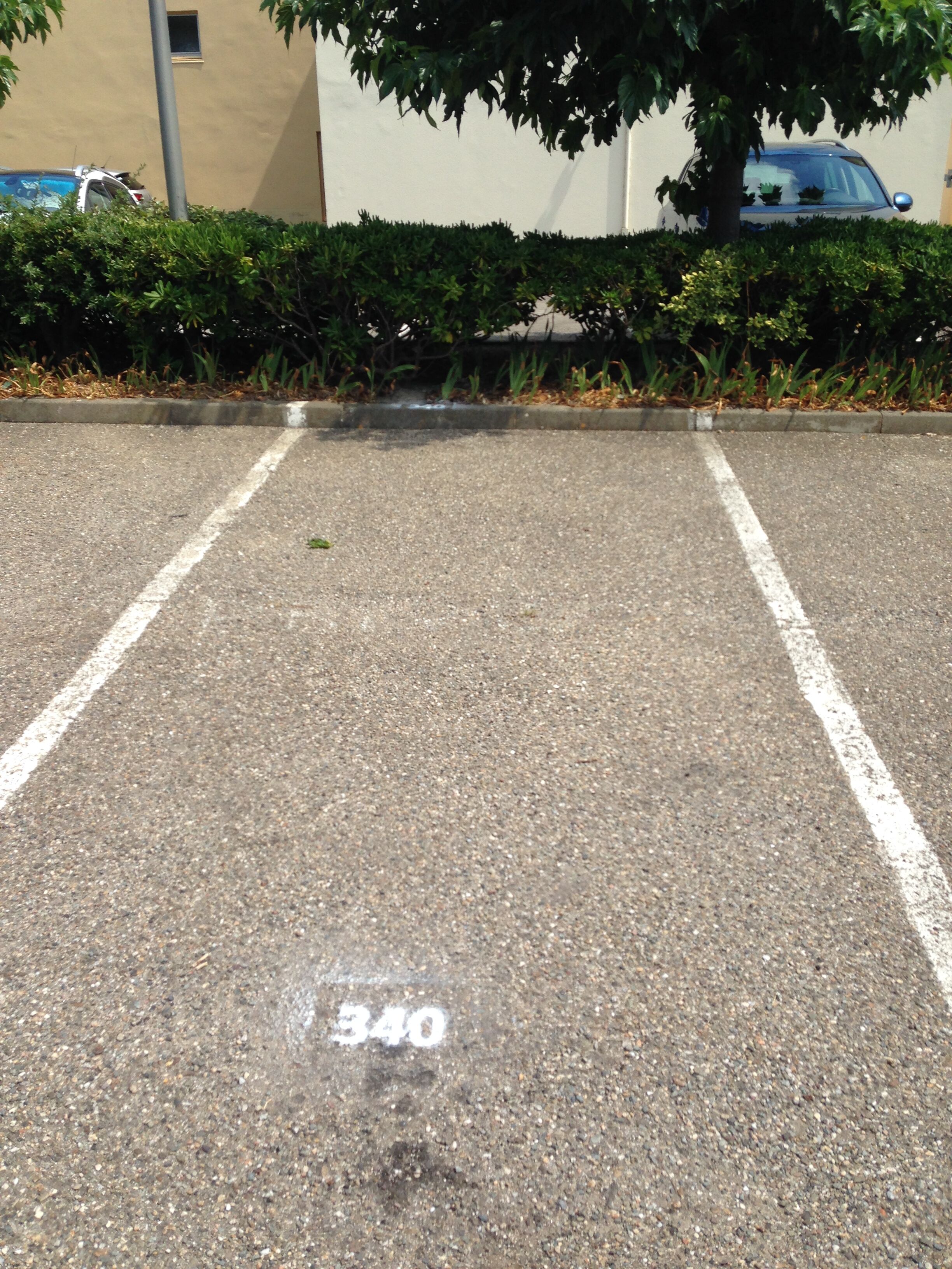 A parking lot with white lines marking parking spaces and a number '340' painted on the ground.