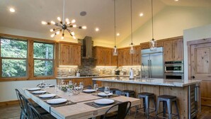 A modern kitchen with wooden cabinets, a large island, and stainless steel appliances. - ⭐️Luxury newly built with Sauna, Steam and Hot Tub  (Truckee)
