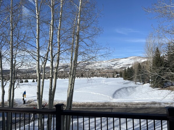 A snowy landscape with a clear view of a mountain range and a body of water.