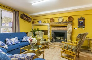 TV connectée, cheminée, table de tennis de table, livres