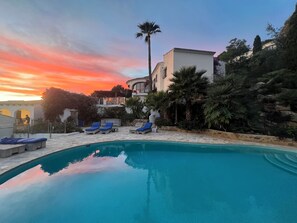 A swimming pool with lounge chairs, a palm tree, and a building with a balcony. - Idyllic & luxury huge 7 bed / bath villa, heated pool & Jacuzzi Wifi (Xàbia)