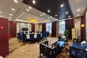 A hotel room with a dining area, a TV, a large window, and a plant. - Dexing Hotel (Dexing)