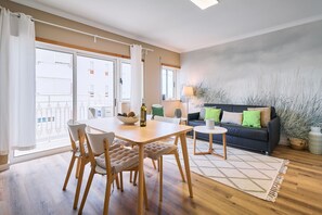 Un salon moderne comprenant un coin repas, un canapĂ© et une vue sur lâextĂ©rieur.