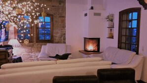 A cozy living room with a fireplace, stone walls, and a comfortable seating area. - Quiet holiday villa with pool and stunning sea views for up to 10 people (Cavalaire-Sur-Mer)