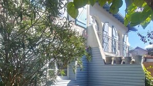 A patio with a table and chairs, surrounded by plants and a house with blue siding. - Quiet Capbreton house at the marina, between beaches and amenities (Capbreton)