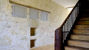 A rustic interior with a wooden staircase, stone walls, and a built-in shelf. - Maison de Maître 12 pers / private pool - Biran- GERS  (Biran)
