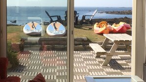 Un patio con vista al mar, con sillones de descanso y flotadores inflables.