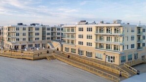 Un hotel de varios pisos con un patio central, balcones y techo plano.