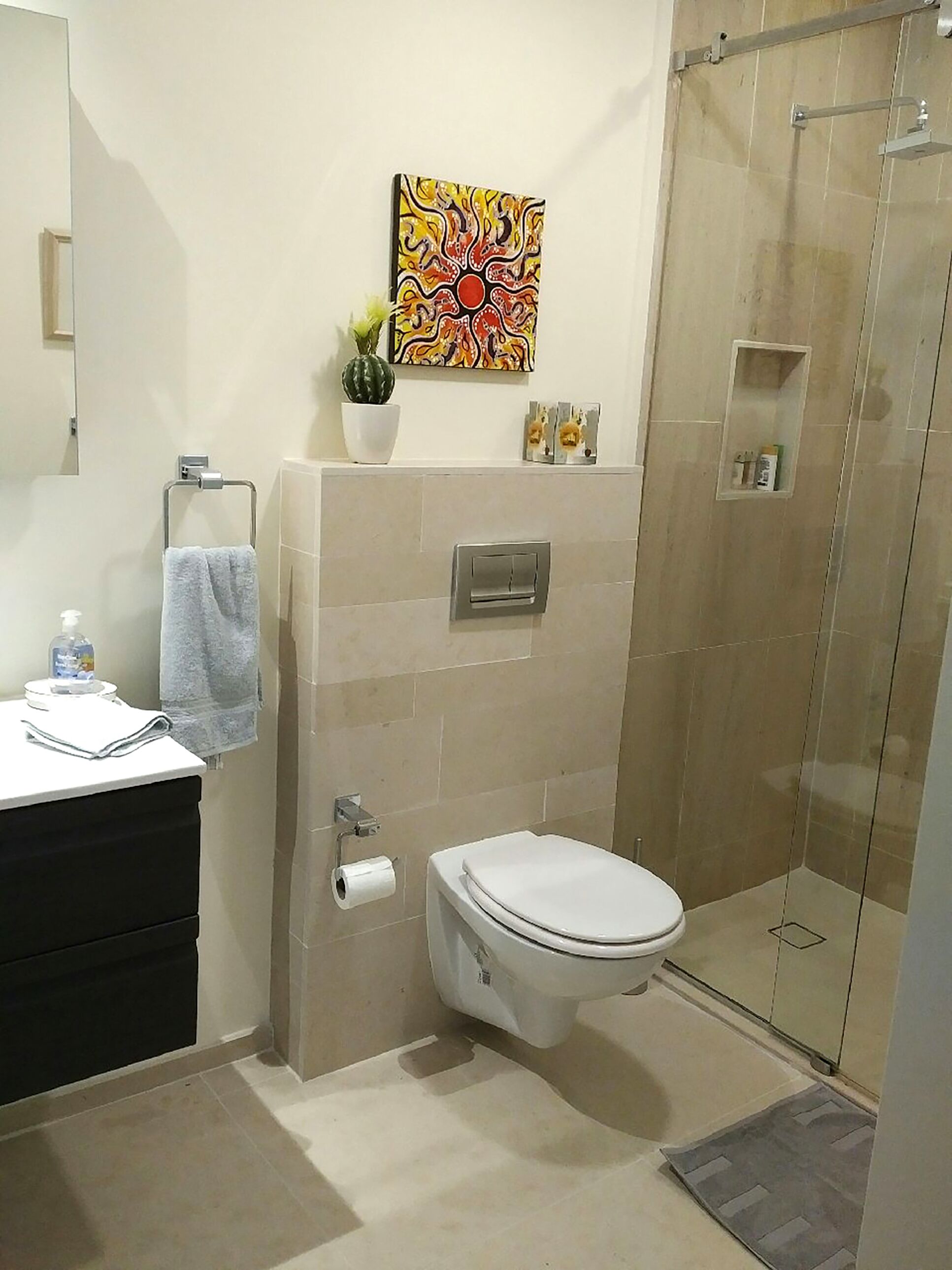 Een moderne badkamer met toilet, wastafel en douche.