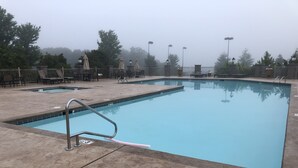 A rectangular swimming pool with a tiled edge, a metal ladder, and a paved deck area with lounge chairs and umbrellas. - 5-Star Branson Hills Villa - 4 Master Suites, Sleeps Up to 10, Pool & Golf (Branson)