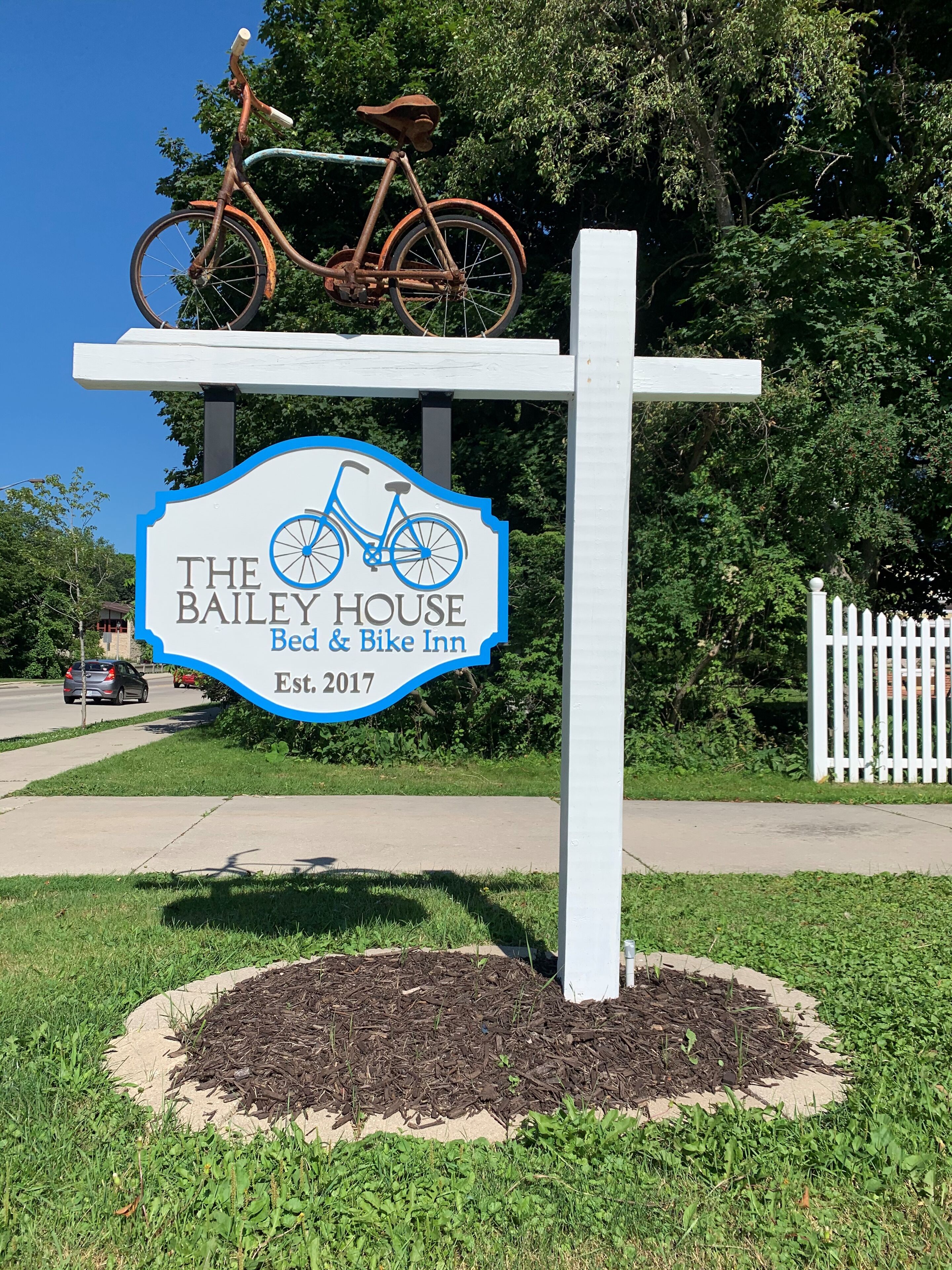 Een bordje voor The Bailey House Bed & Bike Inn, met een fiets erop bevestigd.